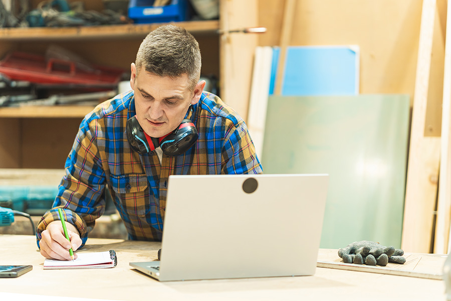 Tradesperson writing customer notes by hand instead of using a CRM system